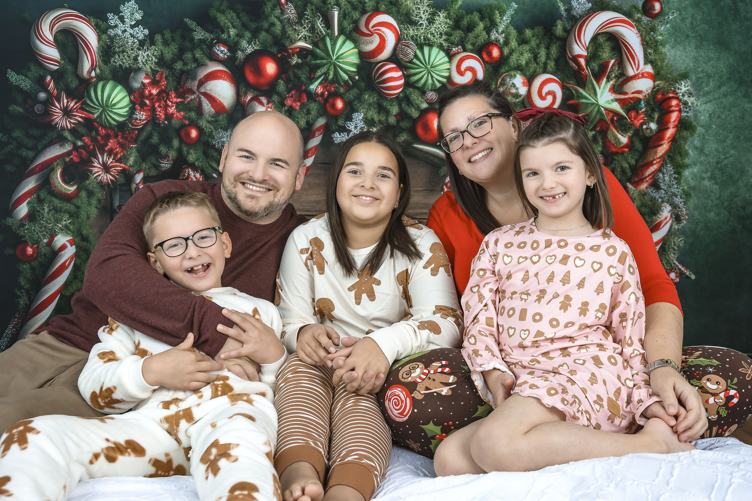 Fine art family portrait with three children composed of two girls and one boy holiday bedroom background in studio by Vaudreuil-Soulanges and West Island of Montreal photographer Tobi Malette