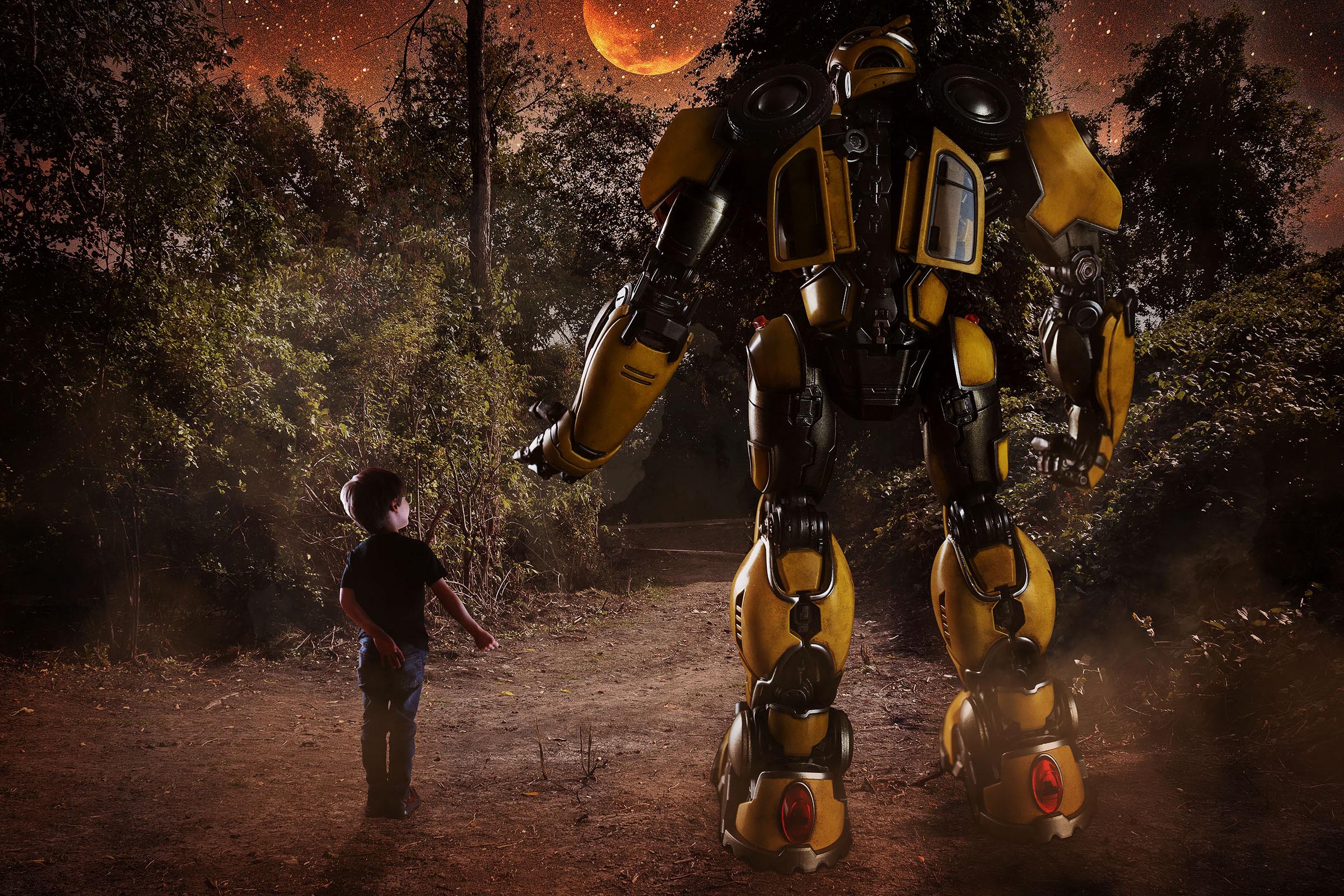 Composite of boy and Transformers Bumblebee holding hand walking in forest night scene with moon by Vaudreuil-Soulanges and West Island of Montreal photographer Tobi Malette